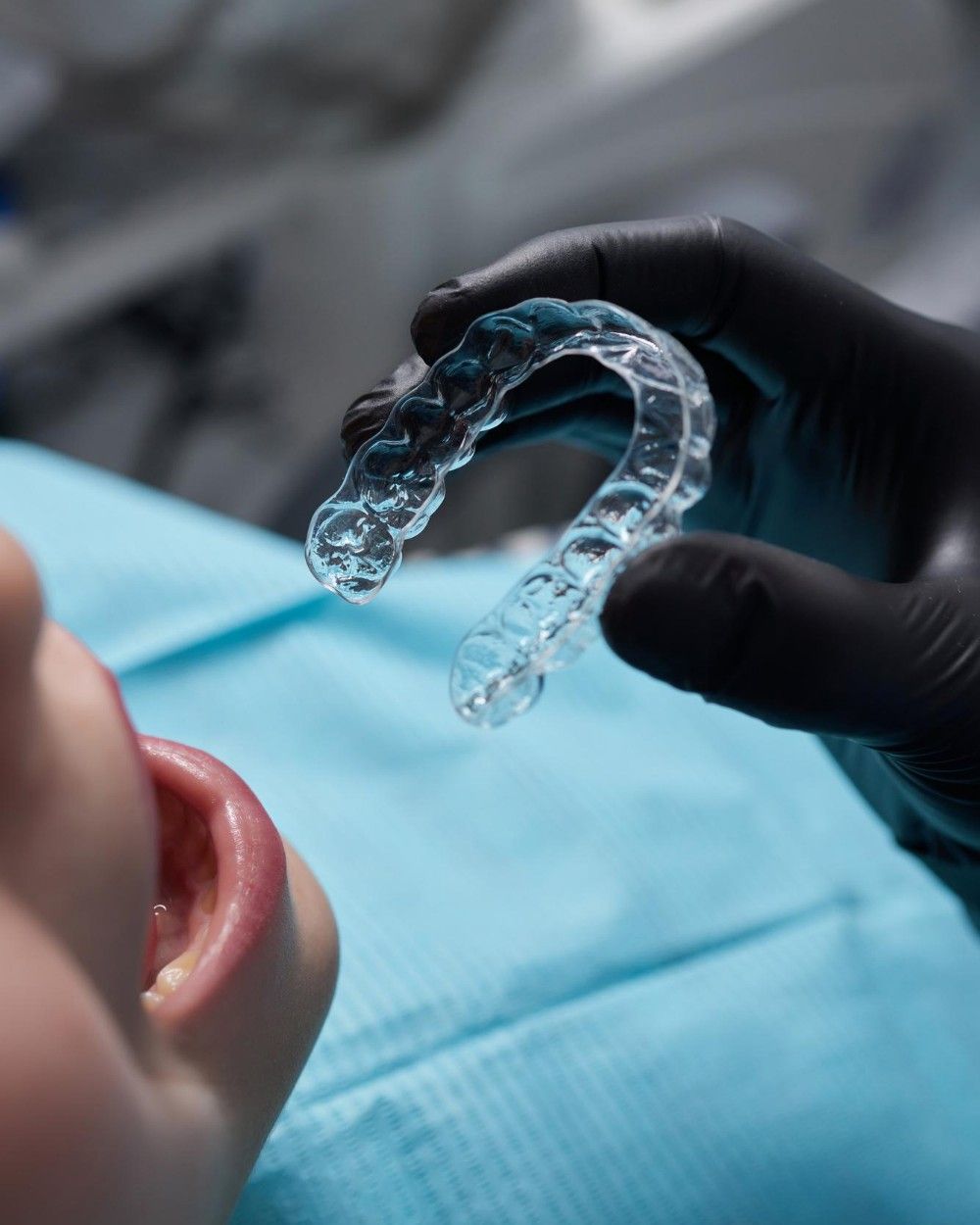 Dentist holding up a custom clear retainer for a patient at iCare Dental IOI City Mall Putrajaya